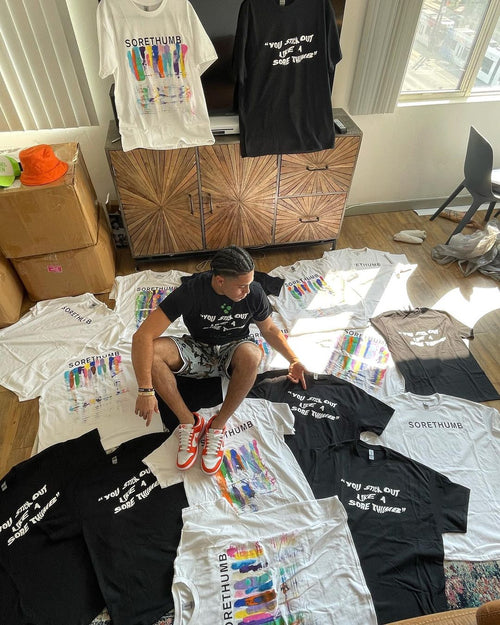 brand owner surrounded by t shirts