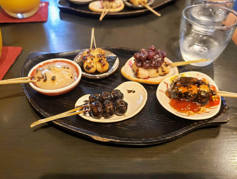 A platter of 5 different types of dango on 5 different plates
