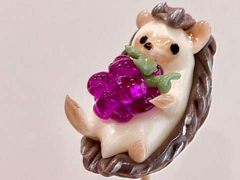 An amezaiku, Japanese candy art, of a hedgehog holding grapes