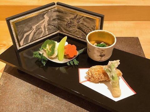 A beautiful tray of dragon art and food in a kaiseki food course