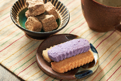 A mall bowl of kokuto cubes and purple and white chinsuko cookies