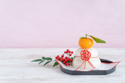Japanese kagami mochi, two large mochi with an orange on top, on a table