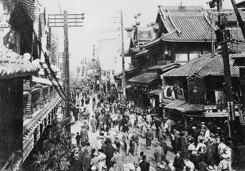 Dotonbori in 1929 with tons of people in kimonos or suits walking in front of the Nakaza Theater