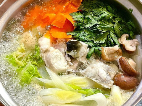 A boiling hotpot of fugu meat, mushroom, parsley, onion and other veggies
