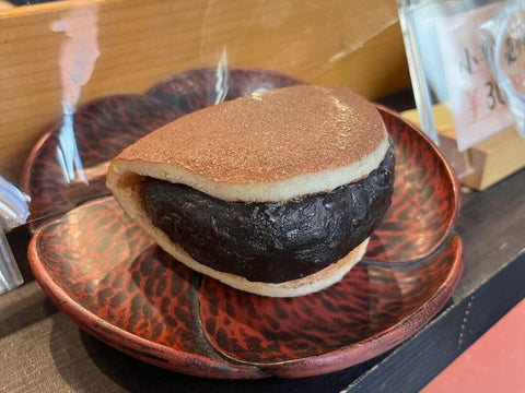 A dorayaki with a single cake patty wrapped around a lot of anko