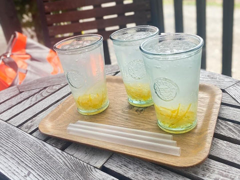 Three glasses of yuzu sour, an alcoholic beverage, with the rind sitting towards the bottom