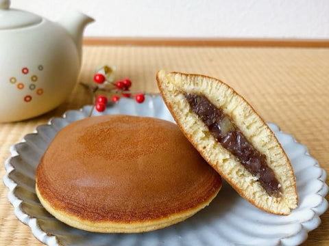 A dorayaki split in half on a plate to show the bean paste