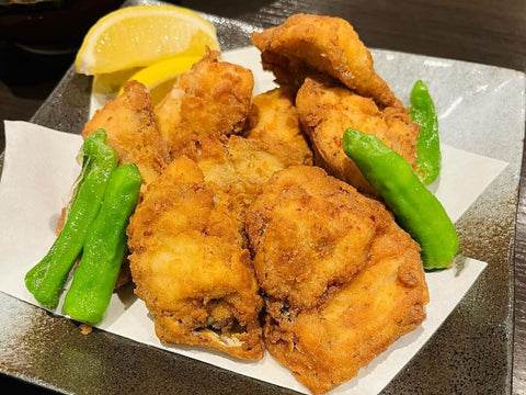 Several pieces of golden fried fugu sit on a plate