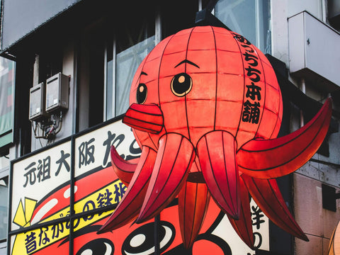 A giant octopus lantern hangs from a building advertizing takoyaki