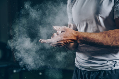 Athlete applying chalk on hands