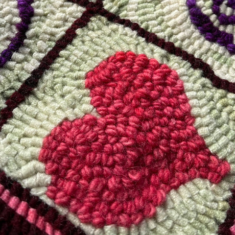 Heart rug hooking project with yarn and wool strips