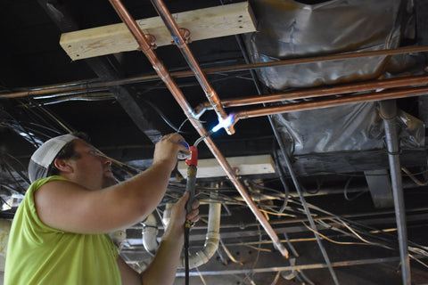 Master Plumber Jack Grimm Jr. welds new copper pipes for The Tavern on the Square