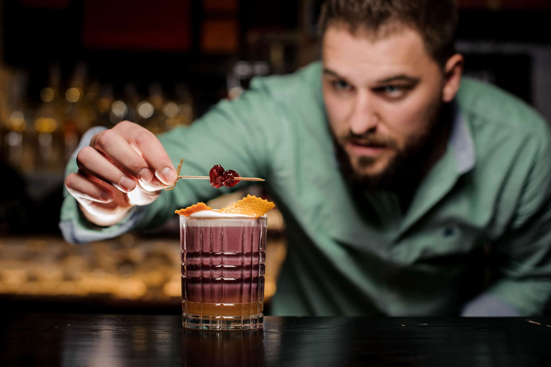 Bartender finishes New York Sour cocktail with a garnish