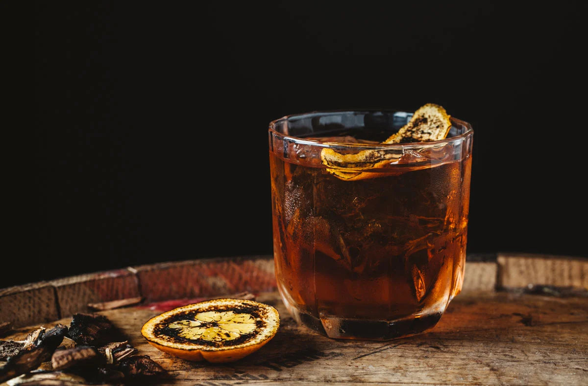 Smoked Old Fashioned Served in a Rocks Glass and Garnished with a Charred Candied Lemon.