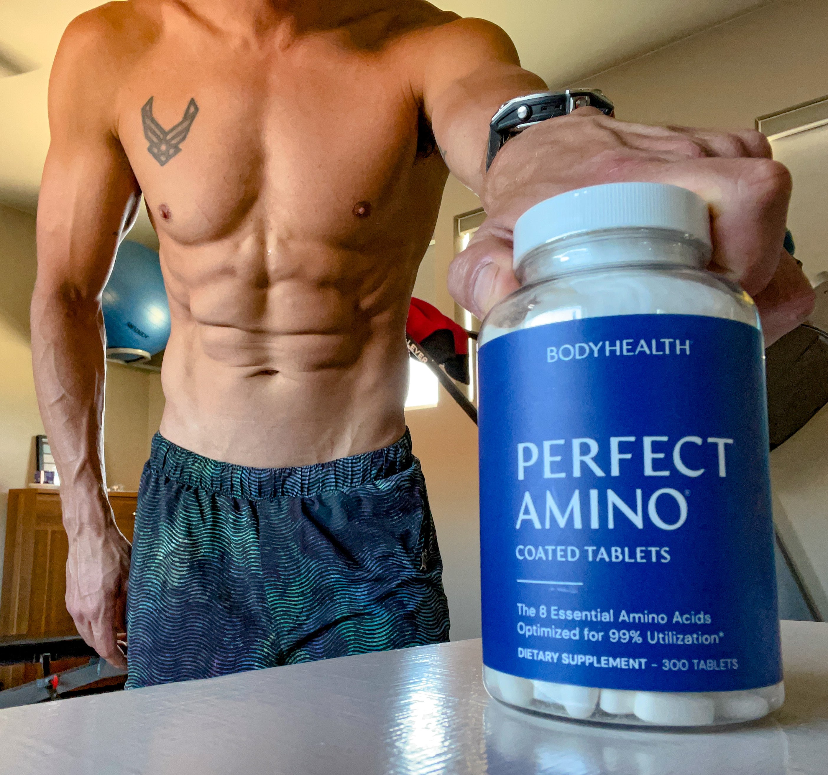 BodyHealth male Influencer holding PerfectAmino bottle of tablets for toned and lean muscle