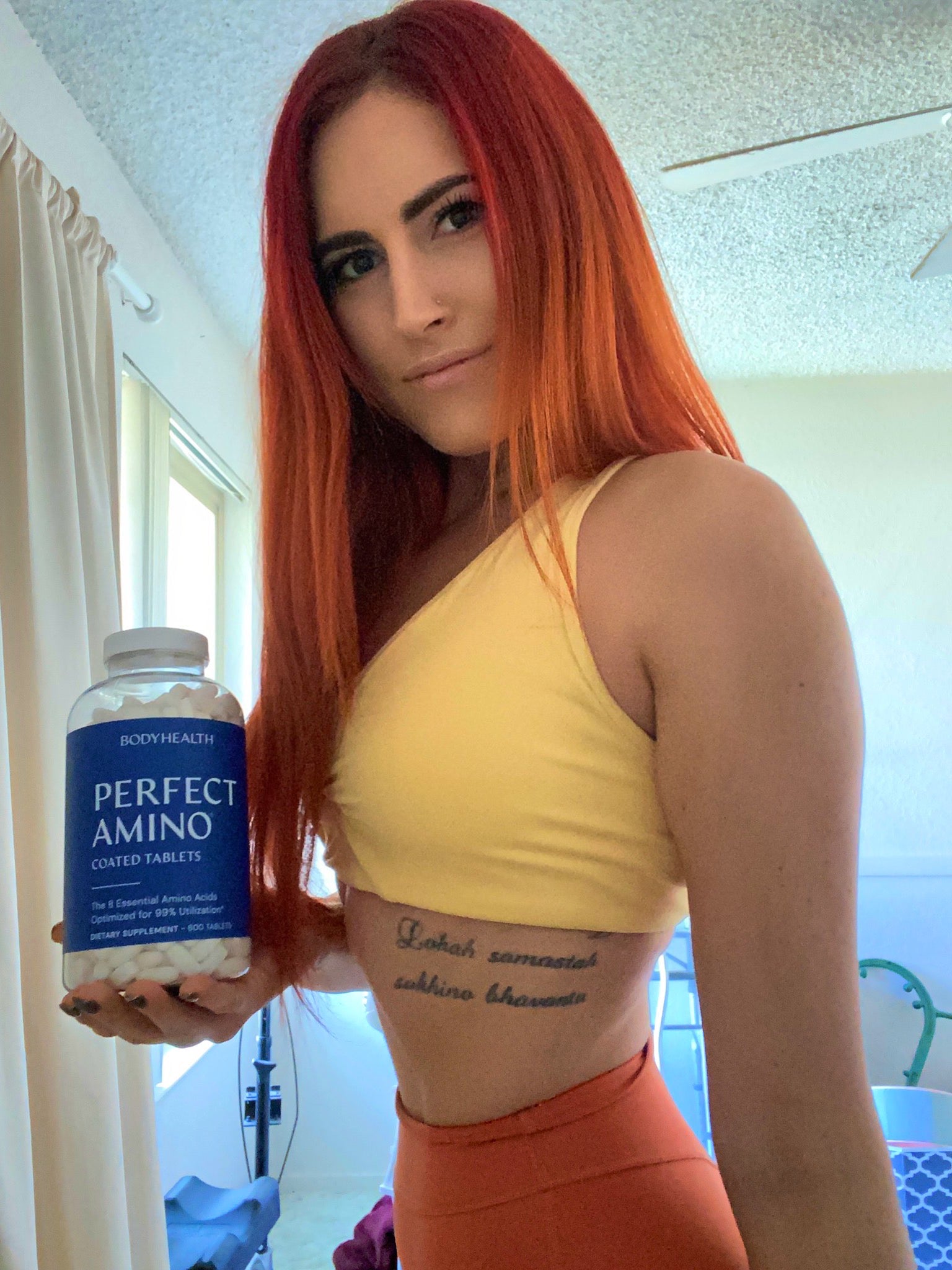 BodyHealth Woman Influencer holding PerfectAmino 150 count bottle of tablets for toned and lean muscle