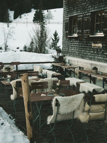 Warm blankets like these ones and a fire pit table from Outdoor GreatRoom Company make for excellent heating solutions for an outdoor business's seating area.