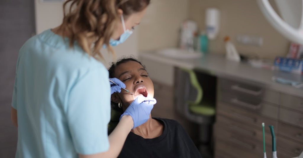 a women dental doctor doing treatment to women mouth