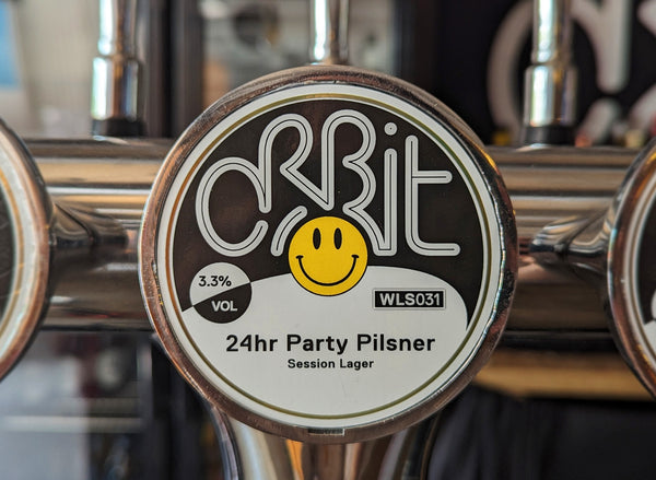 24 hr party pilsner tap badge. Black and white with a yellow acid-house smiley in the middle.