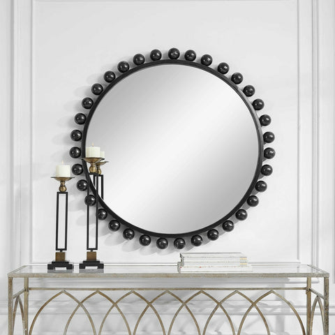 black iron mirror hang vertically in a hallway