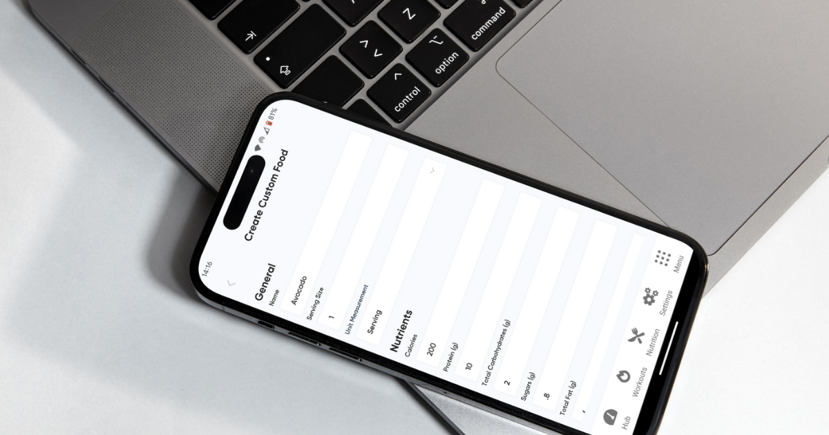 Wild Physio Fitness Nutrition Tracking app for Glute Group and Big and Strong online programs. Phone of the macro calculator ontop of laptop.