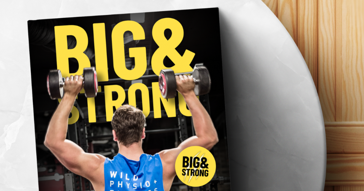 The eBook Big&Strong, fitness guide for men, laying on a marble table with a wooden background.