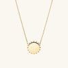 Beaded Pendant Necklace: A handcrafted 14k gold necklace with a circular pendant adorned with delicate beads.