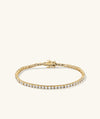 Lab Grown Diamond Tennis Bracelet 2.5mm: A gold bracelet adorned with lab-grown diamonds, featuring a secure clasp and safety arms for easy wear.