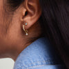 Close-up of a woman's ear wearing Gemstone Mini Studs, handcrafted in 14k solid gold.