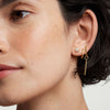 Close-up of a woman's ear wearing Bezel Round Lab Grown Diamond Studs 0.5 ct in 14k solid gold.