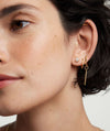 Close-up of a woman's ear wearing Bezel Round Lab Grown Diamond Studs 0.5 ct in 14k solid gold.