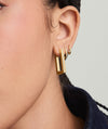Close-up of a woman's ear wearing Block Large Hoops, inspired by angular, modernist architecture, highlighting the earrings' bold and geometric design suitable for everyday wear.