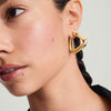 Woman wearing Patra Oversized Hoops, a pair of lightweight gold earrings designed for comfort. Close-up of earring and ear visible.