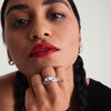 Woman with red lipstick and black hair holding her chin, showcasing the Patra Chunky Ring on her finger, highlighting bold, elegant fashion accessories.