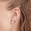 Close-up of a woman's ear wearing Bold Pearl Ear Jacket Studs, featuring a removable earring post with freshwater pearls and gold vermeil detailing.