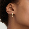 Single Star Hoop Charm on a person's ear, showcasing a gold hoop earring with a star-shaped pendant, ideal for personalizing your eardrobe.