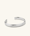 Bold Cuff: A sleek silver bracelet featuring a simple, bold silhouette, perfect for versatile fashion pairings.