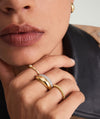 Close-up of a woman's hand wearing the Thin Dôme Ring, a 14k solid gold, ultra-light, bold design ring.