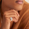 Close-up of a man's hand wearing a Bold Round Signet Ring, showcasing its detailed craftsmanship in sterling silver.