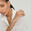 Woman with braided hair wearing a white shirt and gold Ultra Slim Rectangular Signet Ring, showcasing its delicate design on her finger.