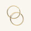 Tube Oversized Hoops: A pair of modern, lightweight gold hoop earrings with a clicker closure, designed for effortless wear and maximum comfort.