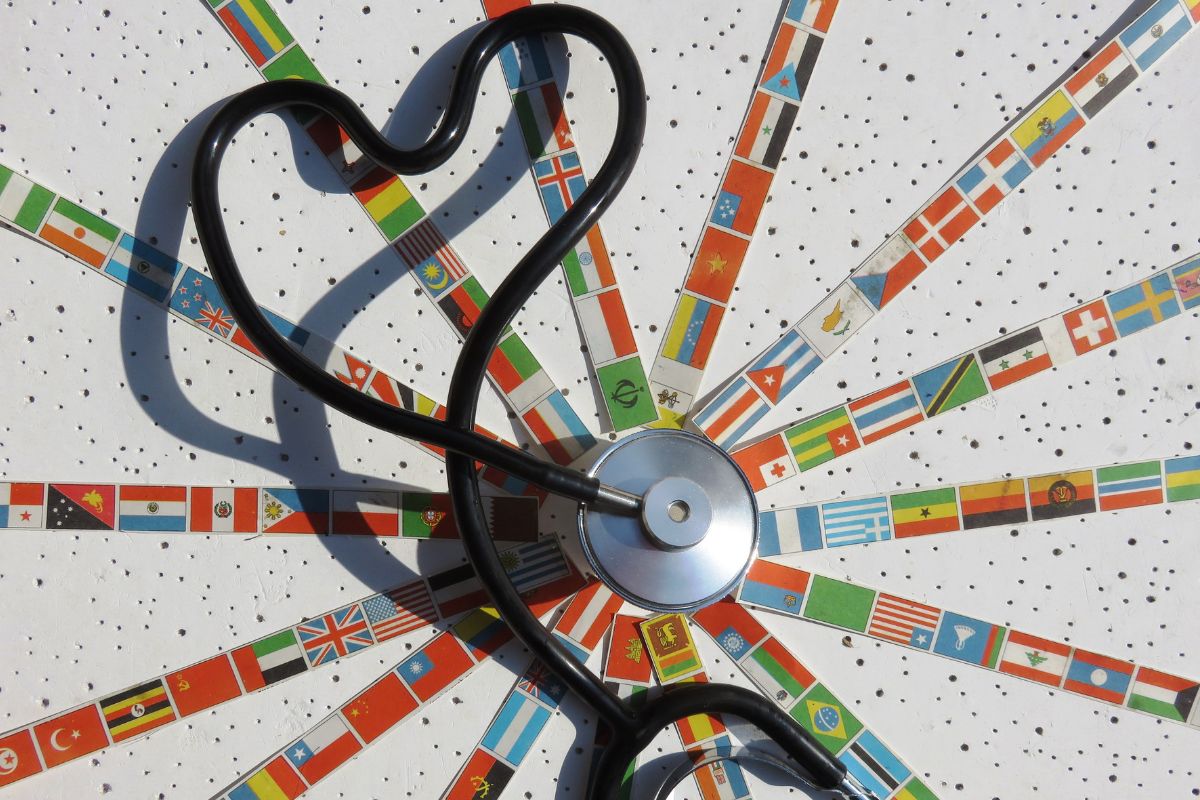 A Stethoscope with small flags of different countries around it.