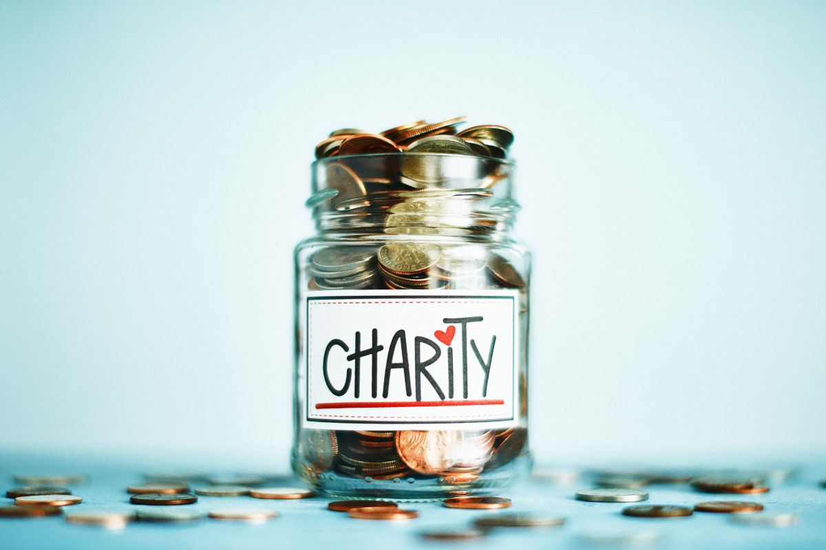 A glass jar full of coins collected as charity.