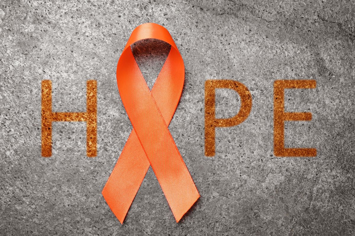 An orange ribbon completing hope word for limb loss awareness.