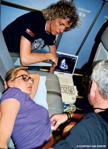 Massimo Pieri observes while Danilo Cialoni uses ultrasound to look for bubbles in a research subject’s heart during flight. (Photo from Alert Diver Online)