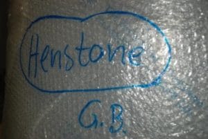 An image of a alcohol still wrapped in bubble wrap with henstone written on in blue ink
