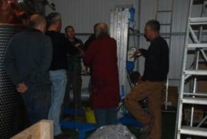 An image of a group of men discussing in a warehouse