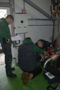 An image of 3 men attending to electrical equipment