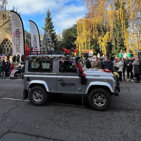 A picture of a land rover defender with a henstone logo printed on the drivers door