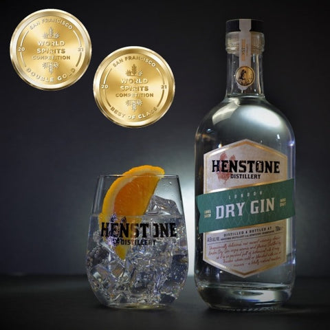 An image of a bottle of henstone dry gin in a henstone branded glass with two gold stamp awards